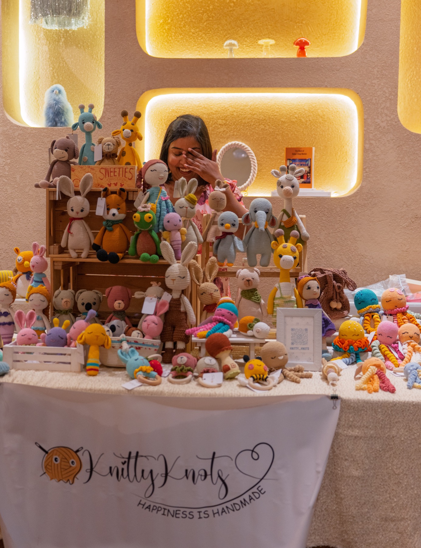 A crochet artist behind her colourful market stall